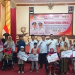 Wakil Wali Kota Pasuruan, M. Nawawi, saat menyerahkan bansos kepada perwakilan penerima di Gedung Gradika Bhakti Praja.