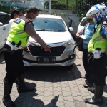 Kedua anggota Satlantas Polresta Sidoarjo saat mengamankan mobil curian asal Pamekasan.