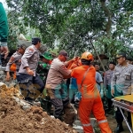 Petugas saat mengevakuasi jasad korban longsor di Wonosalam Jombang, atas nama Duwi Ayu Wandira Ismail. Foto: AAN AMRULLOH/ BANGSAONLINE