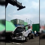 Kontainer saat terlepas dari kendaraan penderek container crane atau Reach Stacker dan menimpa truk di Depo PT BJTI, Perak, Surabaya.