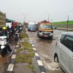 Situasi kemacetan di antara genangan air Jalan Raya Porong.