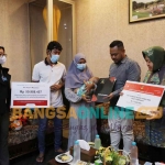 Bupati Gresik Fandi Akhmad Yani bersama Mensos RI Tri Rismaharini saat menyerahkan bantuan. Foto: SYUHUD/BANGSAONLINE.com