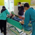 Korban Panut Rianto saat ditangani petugas kesehatan. Korban ditemukan lemas di kursi warung nasi pecel di Desa Tawang Kecamatan Wates, Kabupaten Kediri, Minggu (20/7/2021). foto: ist.
