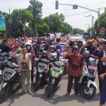 Pengguna jalan saat mengikuti derik-detik proklamasi di depan Pos Polisi Kota Jombang. Foto: AAN AMRULLOH/ BANGSAONLINE