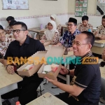 Pj Wali Kota Mojokerto bersama Sekdakot Mojokerto, dan Kepala Dikbud Kota Mojokerto saat menjajal nasi kotak bersama siswa-siswi SMPN 2 Kota Mojokerto. Foto: YUDI EKO PURNOMO/BANGSAONLINE