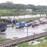 MERAMBAT: Kendaraan harus melambatkan laju saat melewati genangan air banjir di Jalan Raya Porong, Sidoarjo, Kamis (30/6) siang tadi. foto istimewa