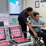 Petugas dari BPJS Kesehatan saat melayani salah satu pasien.