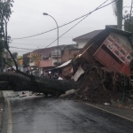 Pohon tumbang di Jalan Diponegoro, Desa Junrejo, Kota Batu, menimpa sebuah warung.