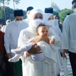 Gubernur Jawa Timur Khofifah Indar Parawansa menggendong cucunya dalam sebuah kesempatan.