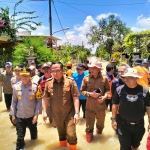 Wakil Bupati Gresik, Asluchul Alif (dua dari kiri), bersama Kapolres Gresik, AKBP Rovan Richard Mahaneru, saat meninjau lokasi banjir luapan Kali Lamong. Foto: Ist.