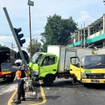 Petugas saat mengatur lalu lintas yang macet akibat kecelakaan antartruk di Traffic Light Pucang, Sidoarjo.
