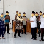 Rias Yudikari saat menyerahkan bantuan masker.