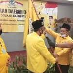 Ketua DPD Golkar Jatim, M. Sarmuji saat menyerahkan Panji Golkar kepada ketua terpilih, Ahmad Nurhamim. (foto: SYUHUD/ BANGSAONLINE).