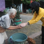 Anggota Polres Bojonegoro sedang membagikan nasi bungkus kepada warga.