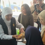 Gubernur Khofifah saat membagikan snack dan minuman secara gratis kepada warga. Foto: Muji Harjita/BANGSAONLINE.com 