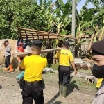 Anggota Polres Ngawi lakukan kerja bakti membersihkan puing-puing bangunan usai diterjang angin puting beliung, Minggu (9/10/2022)