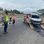 Mobil Ertiga yang terbakar akibat kecelakaan di area Suramadu dievakuasi oleh petugas kepolisian. foto: ist/ bangsaonline.com