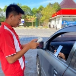 Petugas SPBU di Tuban saat melayani konsumen roda empat yang membeli pertalite menggunakan scan QR code.