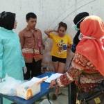 Pegawai Dinas Kesehatan Kota Blitar tengah memeriksa urine salah satu penghuni kos. foto: tri susanto/ BANGSAONLINE