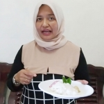 Maimunah Saroh menunjukan tajin mera atau bubur safar yang sudah dibuat dalam rekaman program kuliner BANGSAONLINE TV. foto: bangsaonline.com