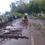 Banjir luapan menyebabkan sebagian badan jalan di jalur lingkar barat, Desa Oro-Oro Ombo, Kecamatan Batu, tertutup material lumpur.