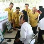 Wabup Moh. Qosim didampingi Sekretaris Perusahaan PG Wahyudi saat mencoba perpustakaan digital. foto: SYUHUD/ BANGSAONLINE