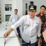 Bupati Pamekasan Baddrut Tamam saat memasukkan surat suara ke dalam salah satu kotak suara.