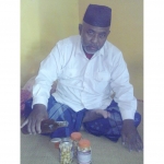 Abah Mustofa menuang madu pada bawang putih lanang yang sudah disiapkan dalam kemasan botol. foto: istimewa/ bangsaonline.com