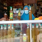 Sumadi didampingi istrinya saat melayani pembeli madu di tokonya di Desa Joho, Kecamatan Semen, Kabupaten Kediri. (foto: MUJI HARJITA/ BANGSAONLINE)