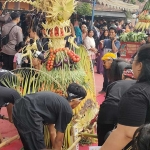 Dua tumpeng besar berisi hasil bumi dan buah-buahan diarak sebelum diperebutkan warga. Foto: MUJI HARJITA/ BANGSAONLINE