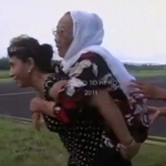 Menteri Kelautan dan Perikanan Susi Pudjiastuti saat menggendong ibunya menuju helikopter.