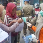 Petugas saat menyosialisakan Surat Edaran Wali Kota Kediri terkait maraknya Corona Virus (Covid-19) di Pasar Dandangan, Kota Kediri. (foto: ist)