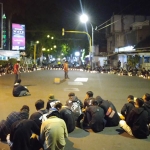 Massa aksi saat menyalakan lilin di perempatan lampu merah sebelah Timur gedung DPRD. foto: TRIWI YOGA/ BANGSAONLINE