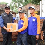 Bupati Lamongan Yuhronur Efendi saat menyerahkan bantuan logistik untuk masyarakat terdampak luapan Sungai Bengawan Solo.