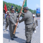 Kepala Satpol PP Gresik, Agustin Halomoan Sinaga (kanan) menyerahkan bendera pataka kepada Sekda Achmad Washil Miftahul Rachman. Foto: Ist.