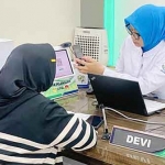 Petugas BPJS Kesehatan saat membantu peserta JKN mengecek status kepesertaan.