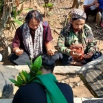 Para pegiat sejarah dari lintas komunitas saat berdoa di Pusara Datuk Tan Malaka di Makam Desa Selopanggung, Kecamatan Semen, Kabupaten Kediri. (foto: MUJI HARJITA/BANGSAONLINE)