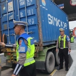 Petugas saat memberi flyer berisi imbauan penggunaan lajur kiri bagi kendaraan truk dan bus di tol.