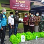 Satker DPMD dan Dinsos Jatim memberikan bantuan sembako bagi keluarga yang di karantina di Karangsono Kanigoro.