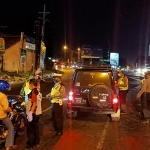 Personel Satlantas Polres pasuruan dibantu anggota Pemuda Pancasila saat memberikan imbauan kepada pengemudi untuk menerapkan physical distancing di Kecamatan Pandaan, Kabupaten Pasuruan.