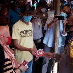 Kapolres Kediri Kota AKBP Miko Indrayana saat membagikan masker kepada para pedagang Pasar Selowarih. (foto: MUJI/ BANGSAONLINE)