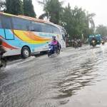 Kendaraan bus ini bergerak lambat akibat genangan banjir, setelah diguyur hujan deras Jumat malam. (ft: rony suhartomo/ BANGSAONLINE)