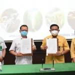 Direktur Utama Petrokimia Gresik Dwi Satriyo Annurogo dan Direktur PTPN X Aris Toharisman saat menunjukkan MoU yang telah ditandatangani. foto: ist.