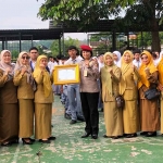 Kepala BNN Kota Batu, AKBP Renny Puspita, saat menyerahkan piagam penghargaan yang diterima Wakil Kepala Sekolah bidang Kesiswaan SMAN 2 Batu, Sri Sondari.