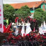 Ratusan Buruh dari Konfederasi Serikat Pekerja Indonesia (KSPI) melakukan aksi unjuk rasa di depan kantor DPRD Jatim. Mereka menuntut penetapan UMK melalui survey KHL. foto: DIDI ROSADI/ BANGSAONLINE
