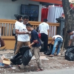Relawan Khofifah-Emil lakukan aksi bersih-bersih sampah di sekitar kantor KPU Jatim. Foto: DIDI ROSADI/BANGSAONLINE