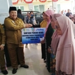 Bupati Jombang, Warsubi didampingi Wabub, Salmanudin Yazid saat menyalurkan bantuan beras secara simbolis ke warga. Foto: AAN AMRULLOH/ BANGSAONLINE