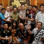Para sopir taksi online bersama Gubernur Jawa Timur Soekarwo, Kapolwiltabes Surabaya, serta Kadishub Jatim foto bersama usai rapat.