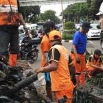 Petugas saat mengambil bungkus kabel yang menyumbat drainase di jalan Medan Merdeka. foto: detikcom