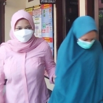 Tersangka menggunakan jilbab hijau saat dgelandang petugas Polsek Wonocolo.